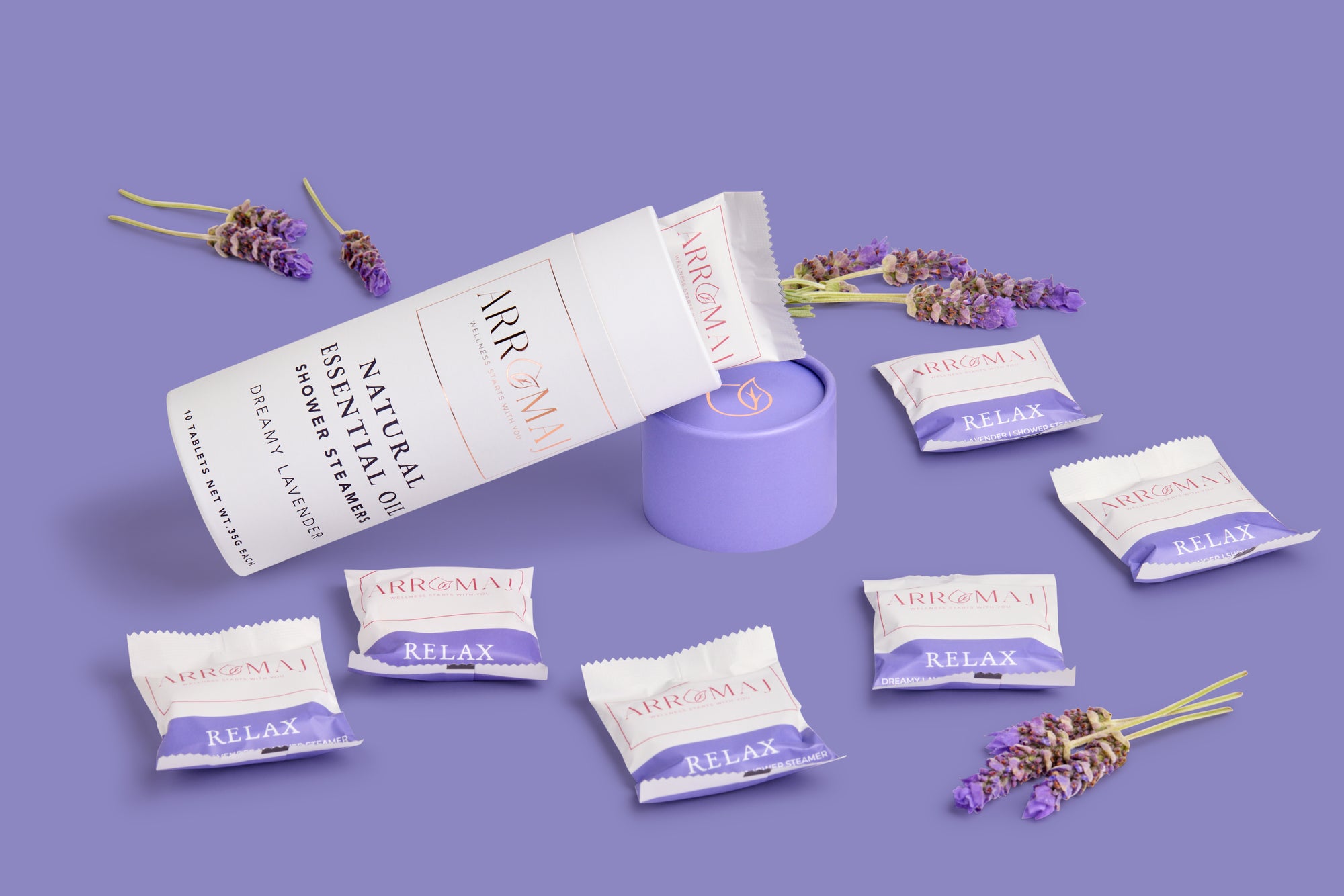 a canister of Arromaj lavender essential oil shower steamer canister and individually packaged shower steamers labeled relax and pieces of lavender
